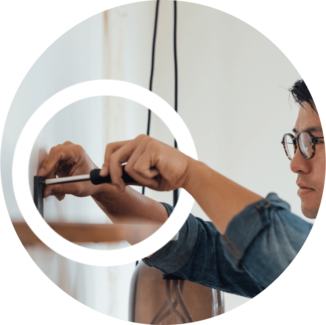 A man fixing a door with a screwdriver depicts how difficult it can be to use tools with MMN.