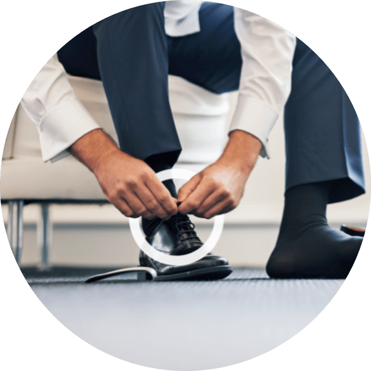 A man tying his shoelaces depicts how difficult it can be if you have MMN.